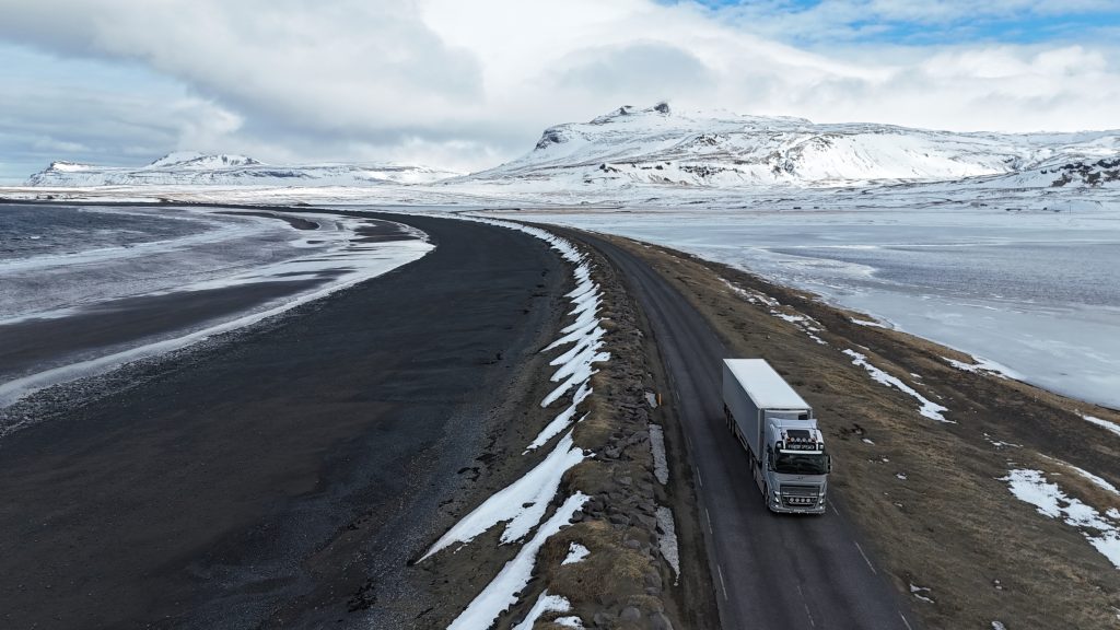Freight tuck drives past black sand beach near the town of Ólafsvík, Snæfellsnes peninsula, Iceland