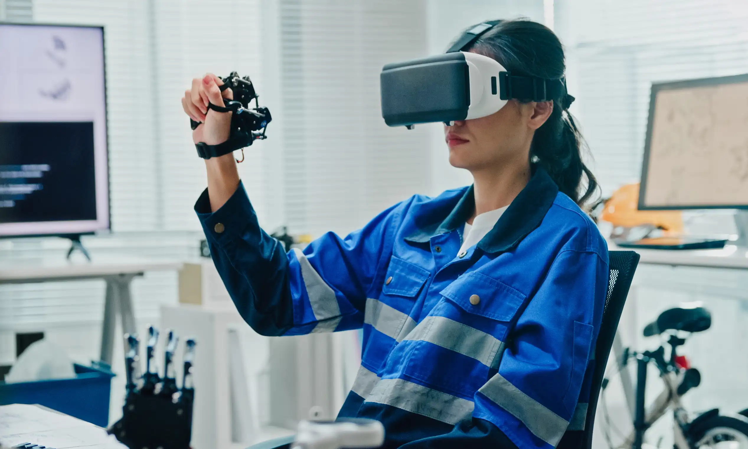 Female-engineer-using-virtual-reality-device A woman working with VR and a robotic hand