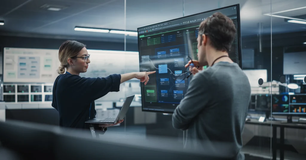security in SoC-based IoT devices blog hero Two security in IoT devices professionals looking at a screen display