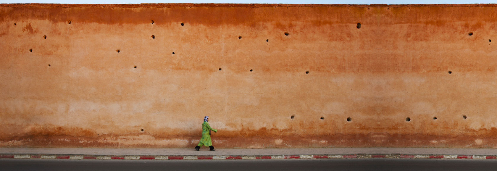 lady walking behind a wall